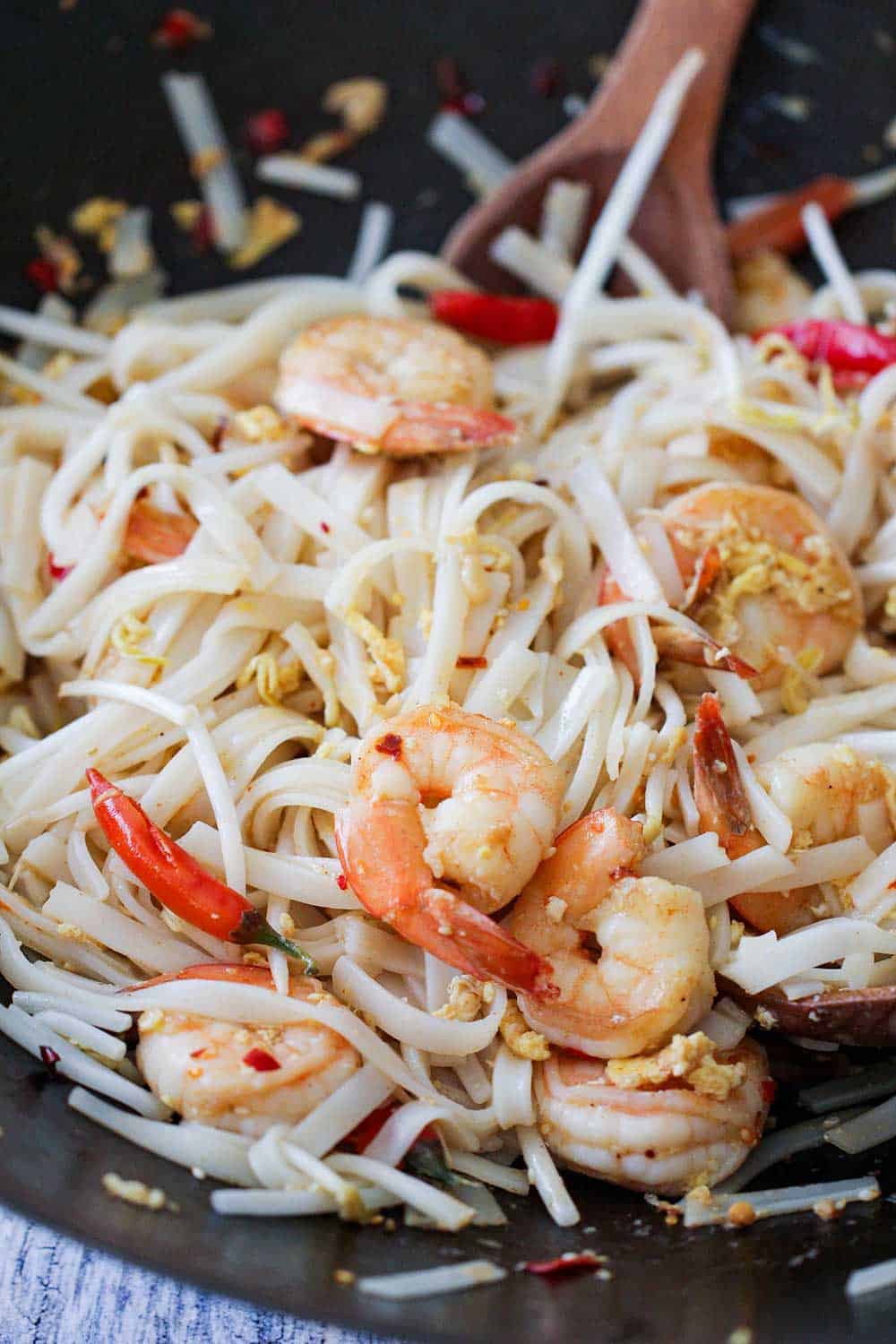 A close up view of authentic shrimp pad Thai in a wok. 