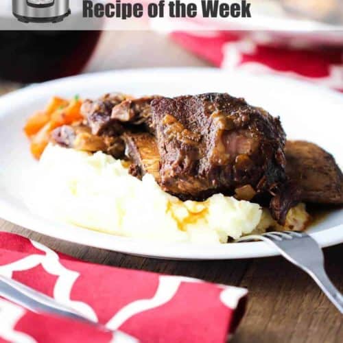 Instant Pot Beef Short Ribs on a white plate next to a red patterned napkin