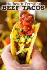 A person using one hand to hold up a crispy beef taco in one hand and drizzling salsa over the top of the taco with the other hand.