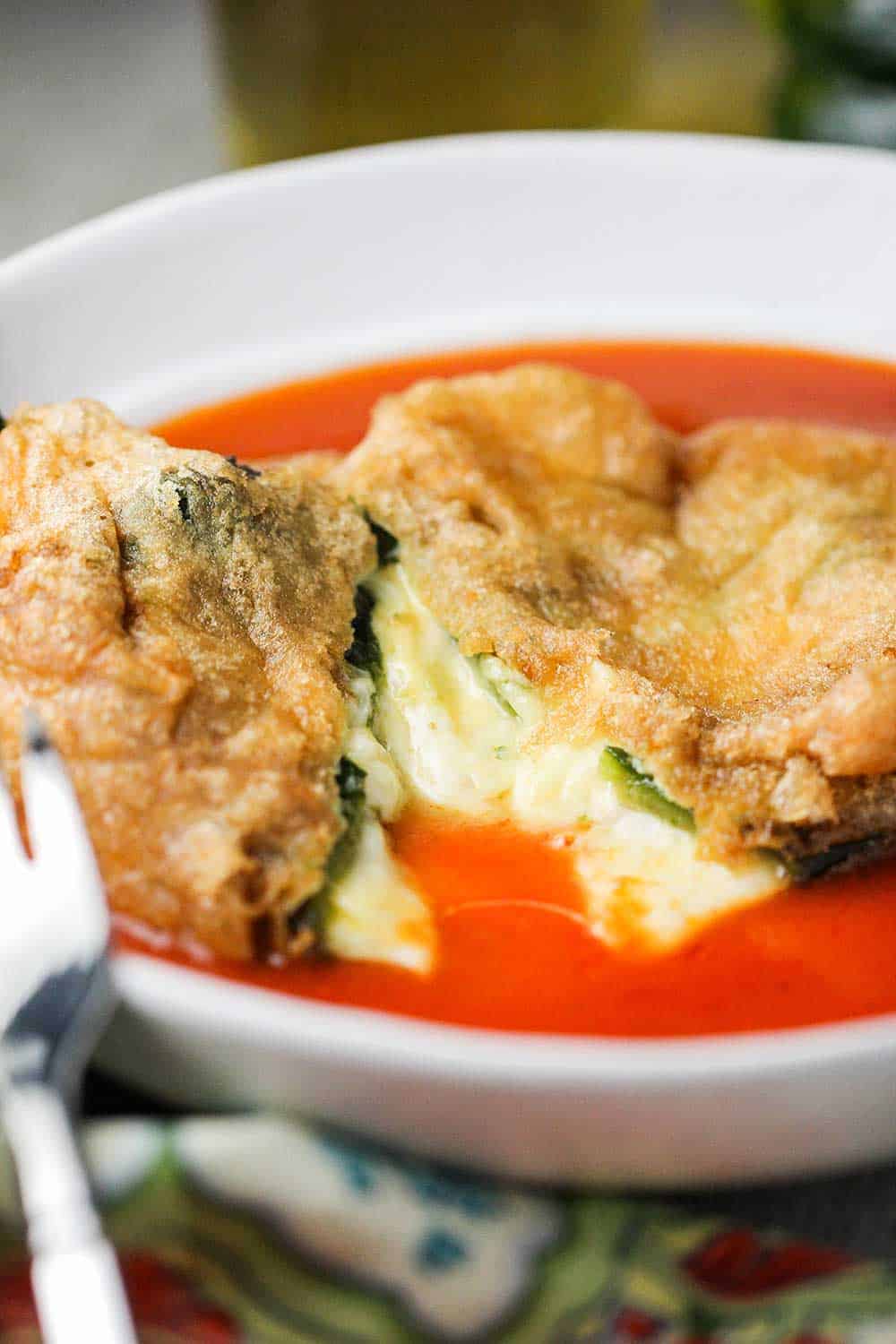 Chile rellenos that is cut in half in a white bowl. 