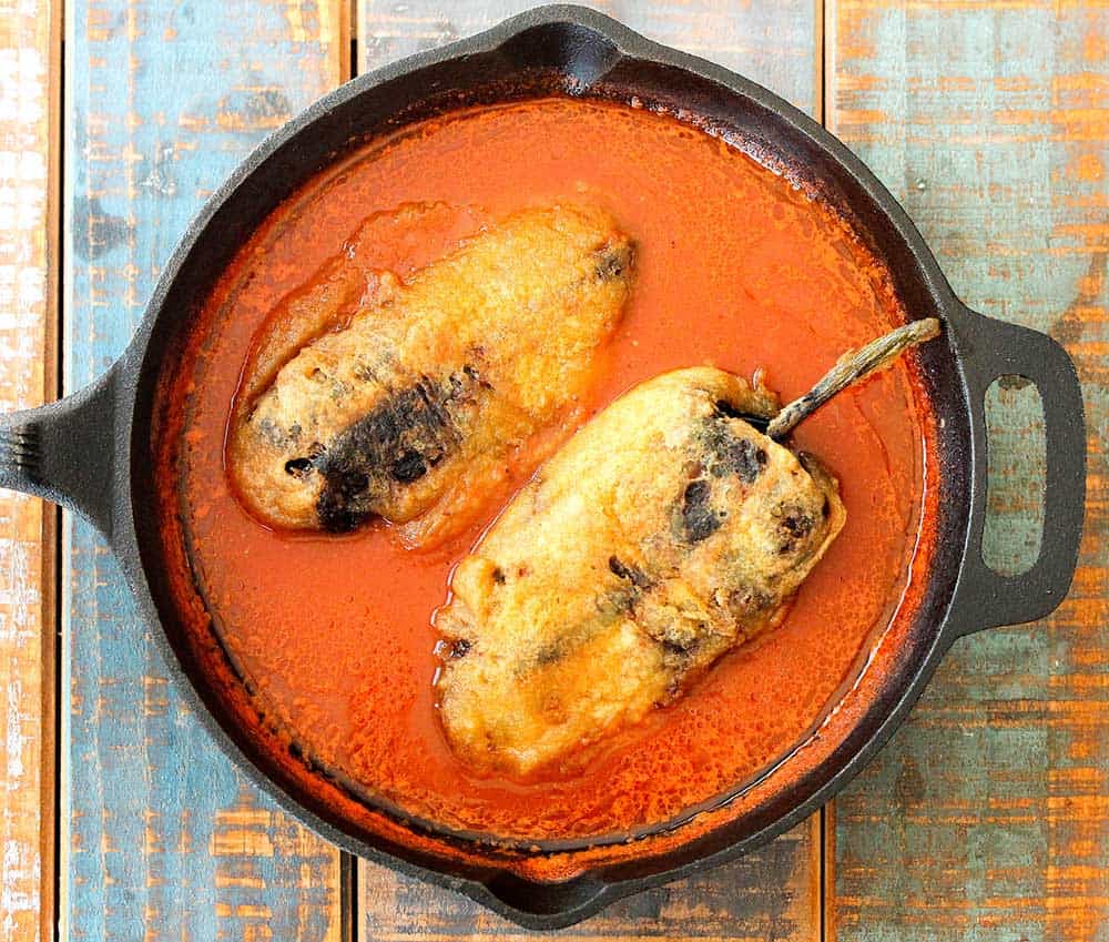 Chile rellenos in a cast iron skillet.