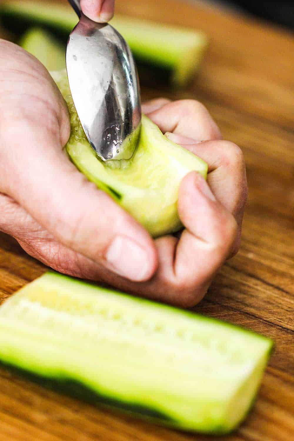 Use a spoon to scoop out the seeds of the cucumber.