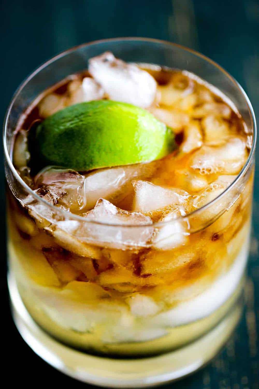 A close up show of the dark and stormy cocktail in a rocks glass.