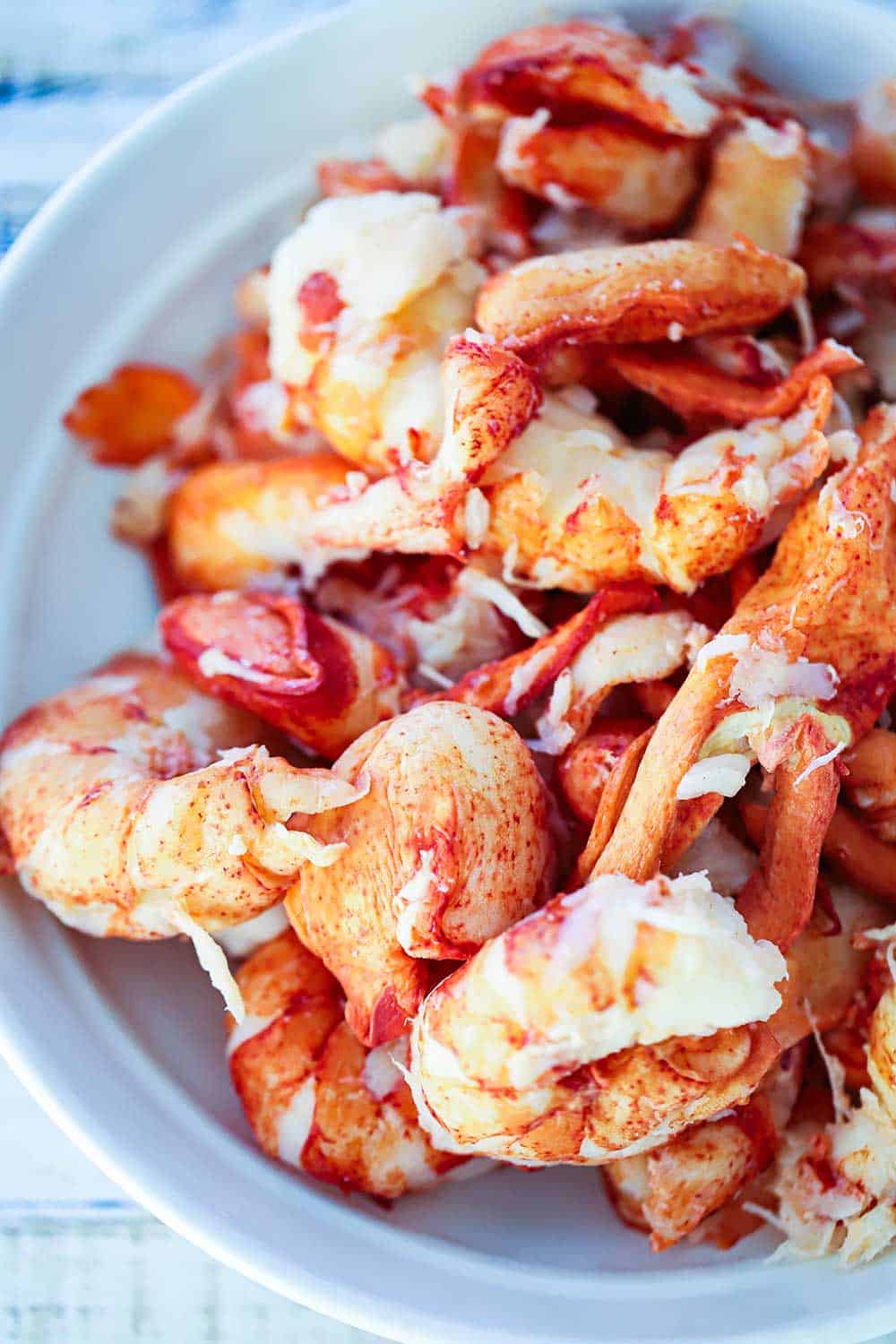 A white bowl filled with large pieces of cooked lobster meat. 