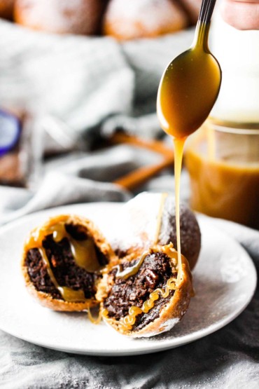 A spoon drizzling butterscotch over deep fried cinnamon cocoa brownies