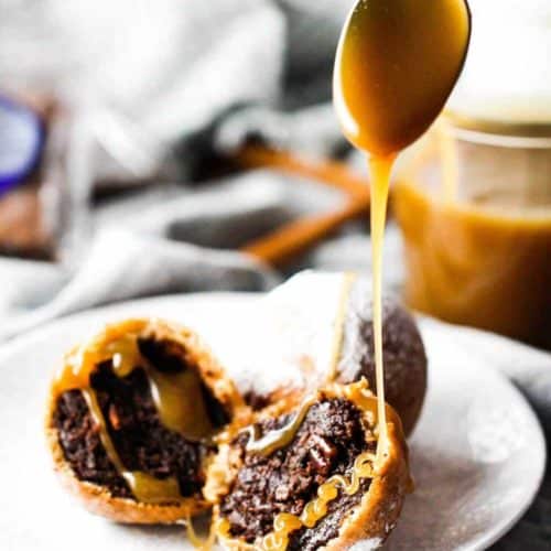 A spoon drizzling butterscotch over deep fried cinnamon cocoa brownies