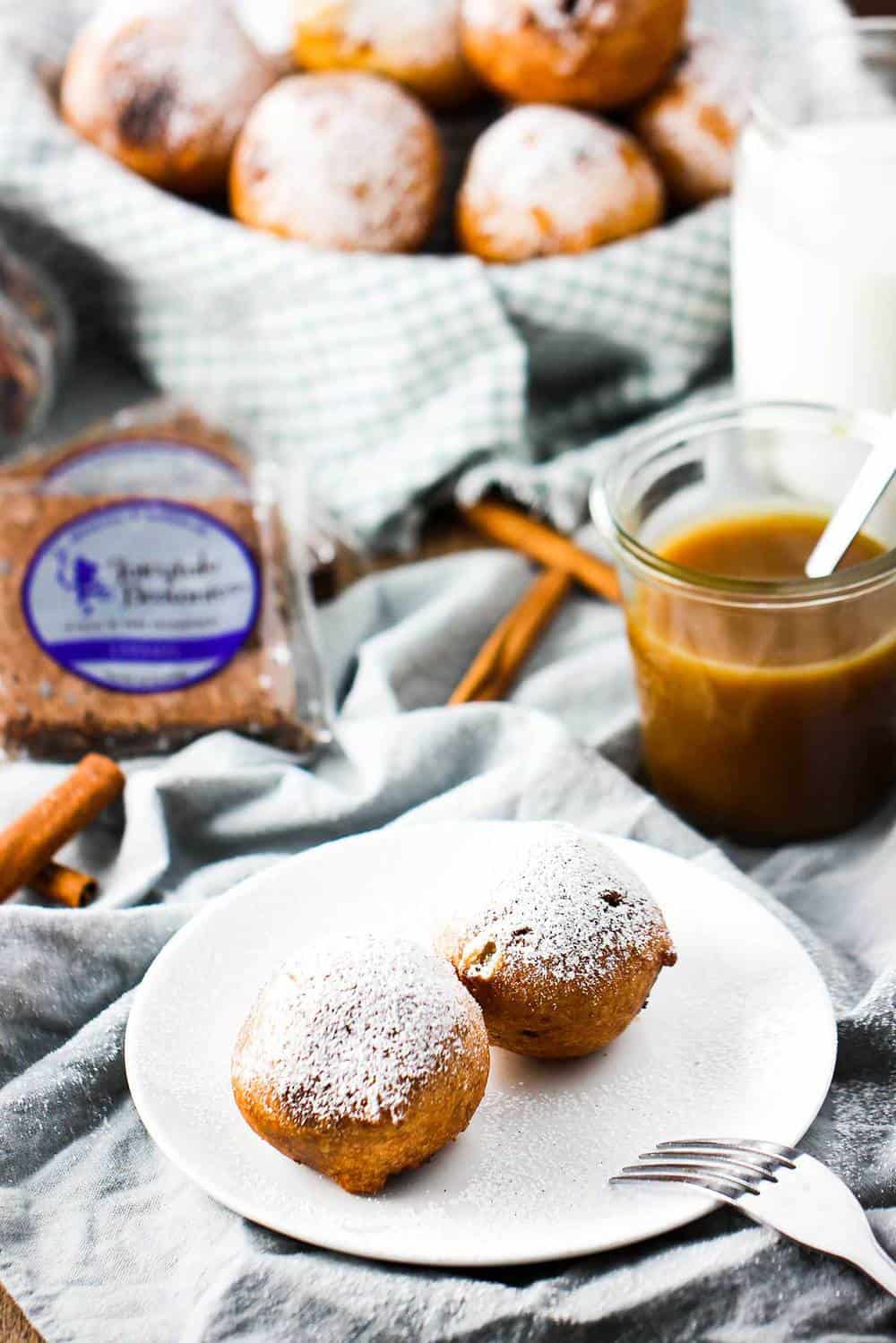 Cinnamon cocoa brownie fritters on a plate with sugar sprinkled on top.