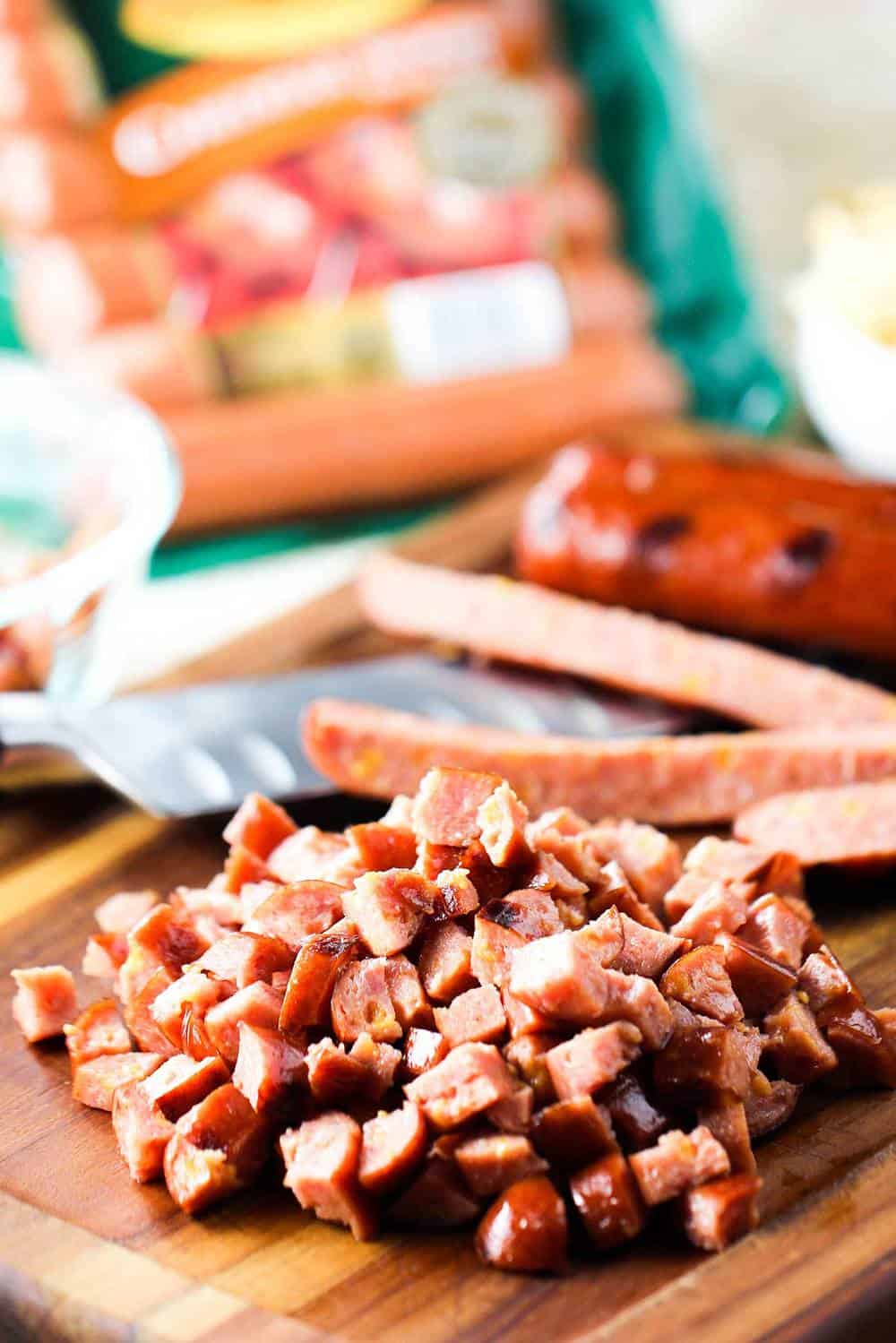 Smoked sausage that is cooked and roughly chopped on a cutting board