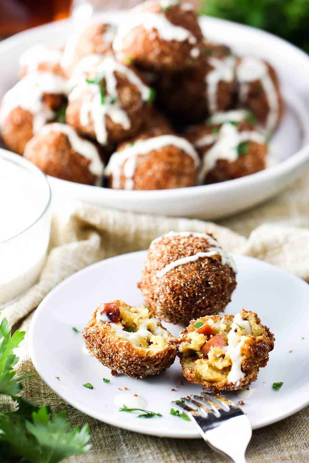 Smoked Sausage with Cheddar beignets on a white plate