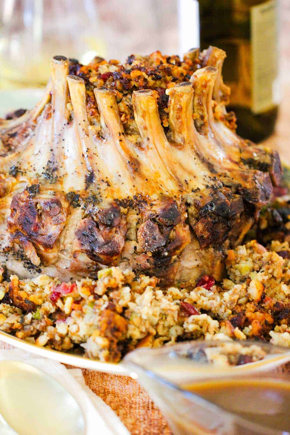 A crown pork roast on a platter with stuffing. 