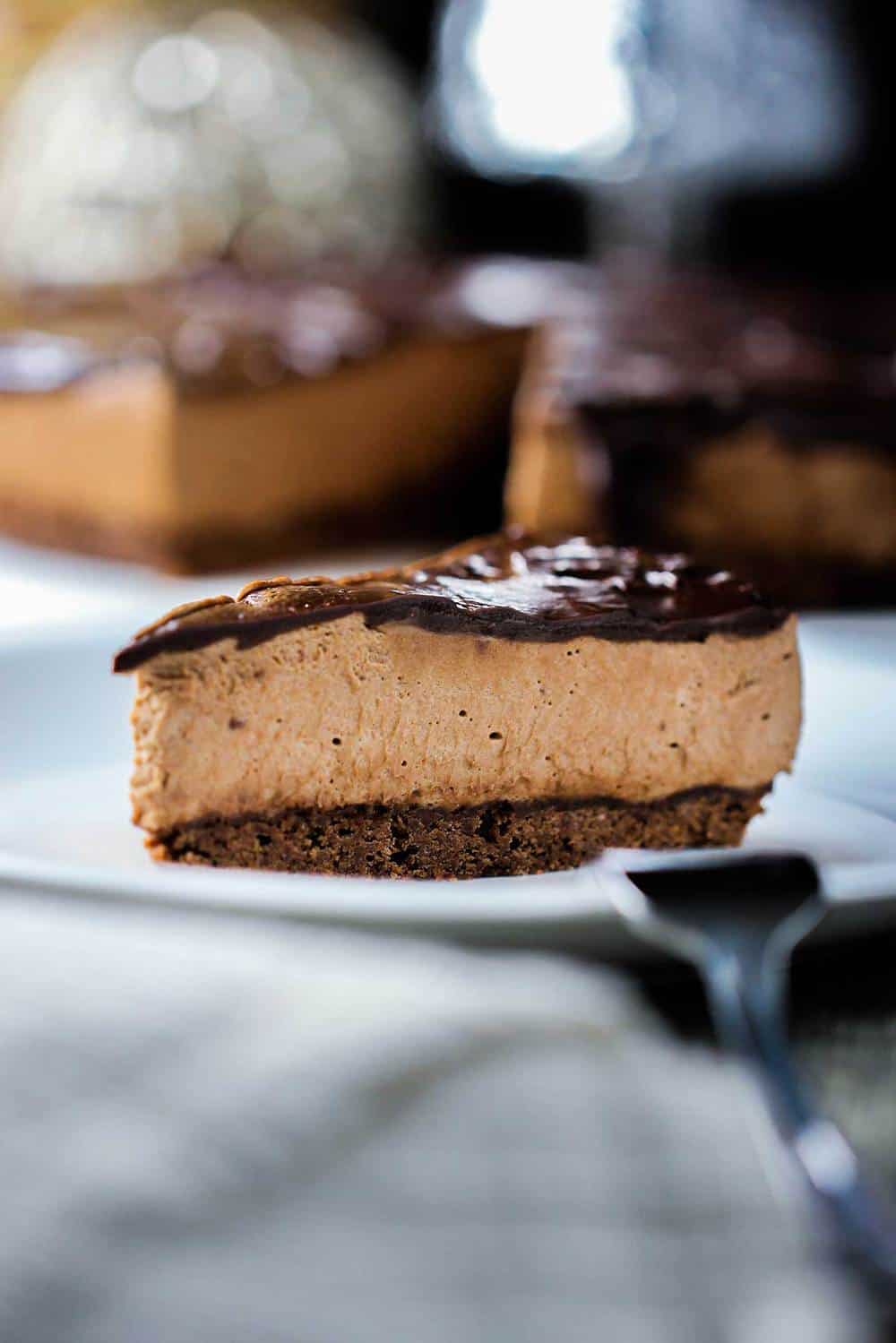 Slice of triple chocolate mousse cake on a white plate