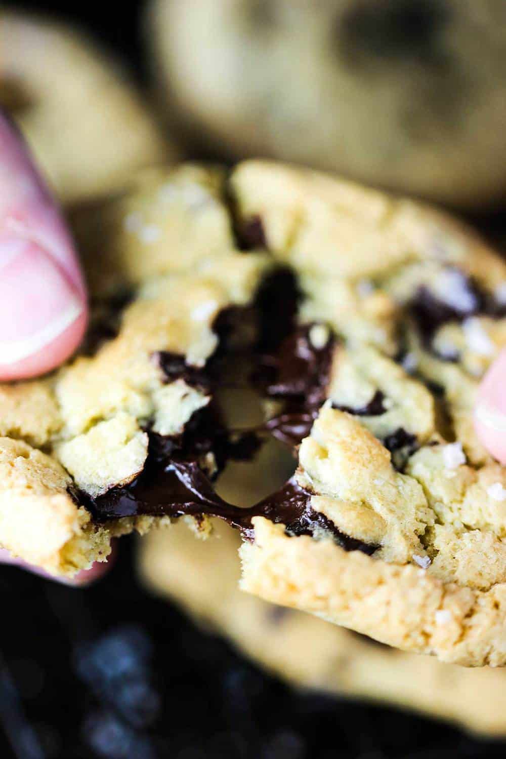 Chocolate chunk cookie being pulled apart with gooey chocolate