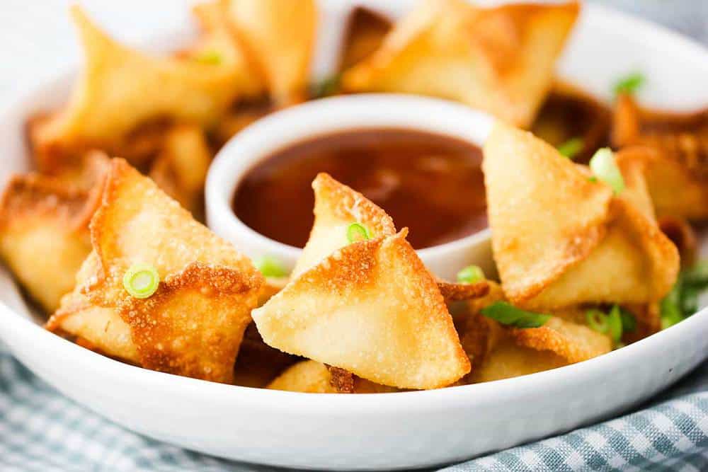 Carb rangoon on a serving platter with sauce