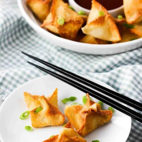 crab rangoon on a plate with chop sticks