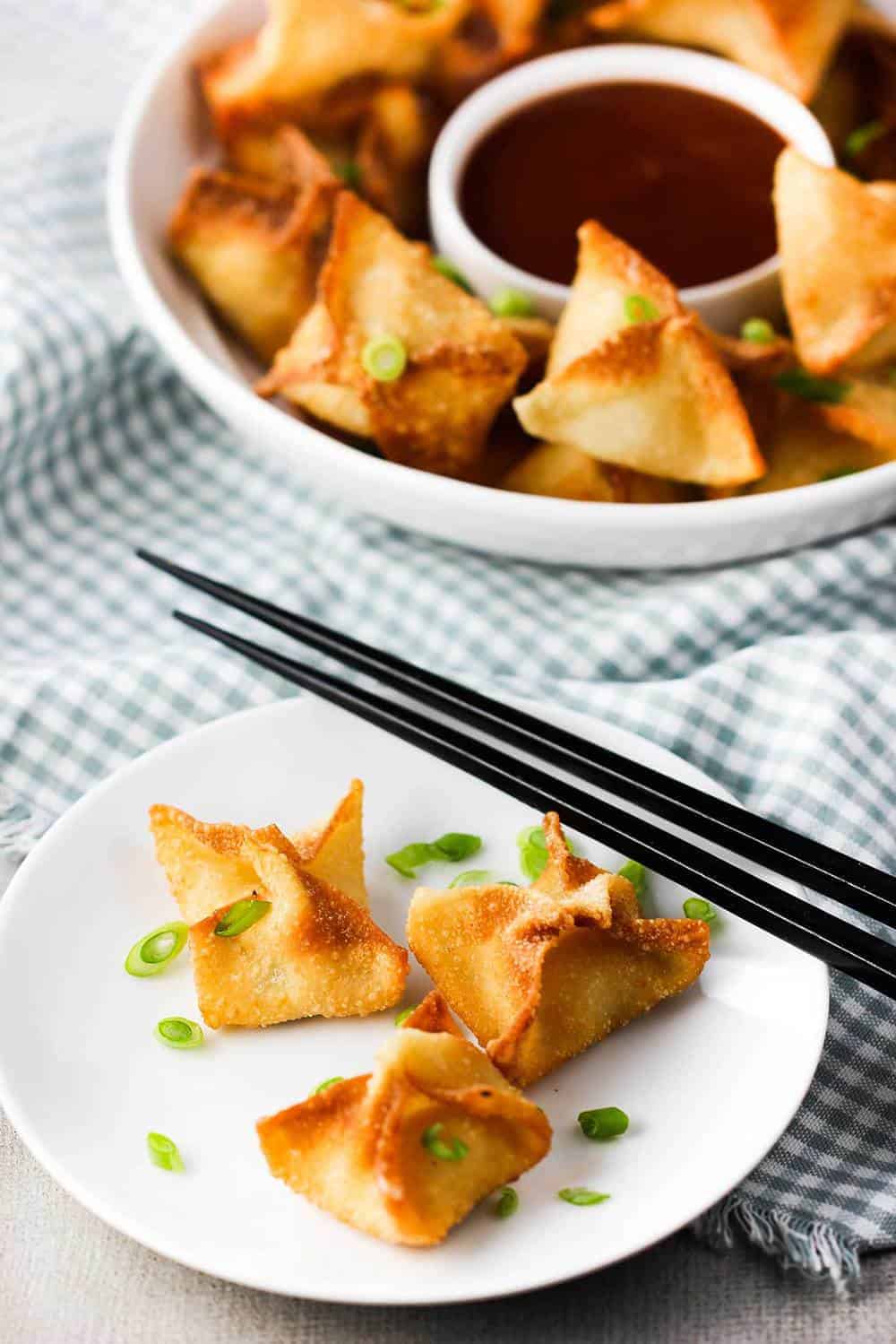 crab rangoon on a plate with chop sticks