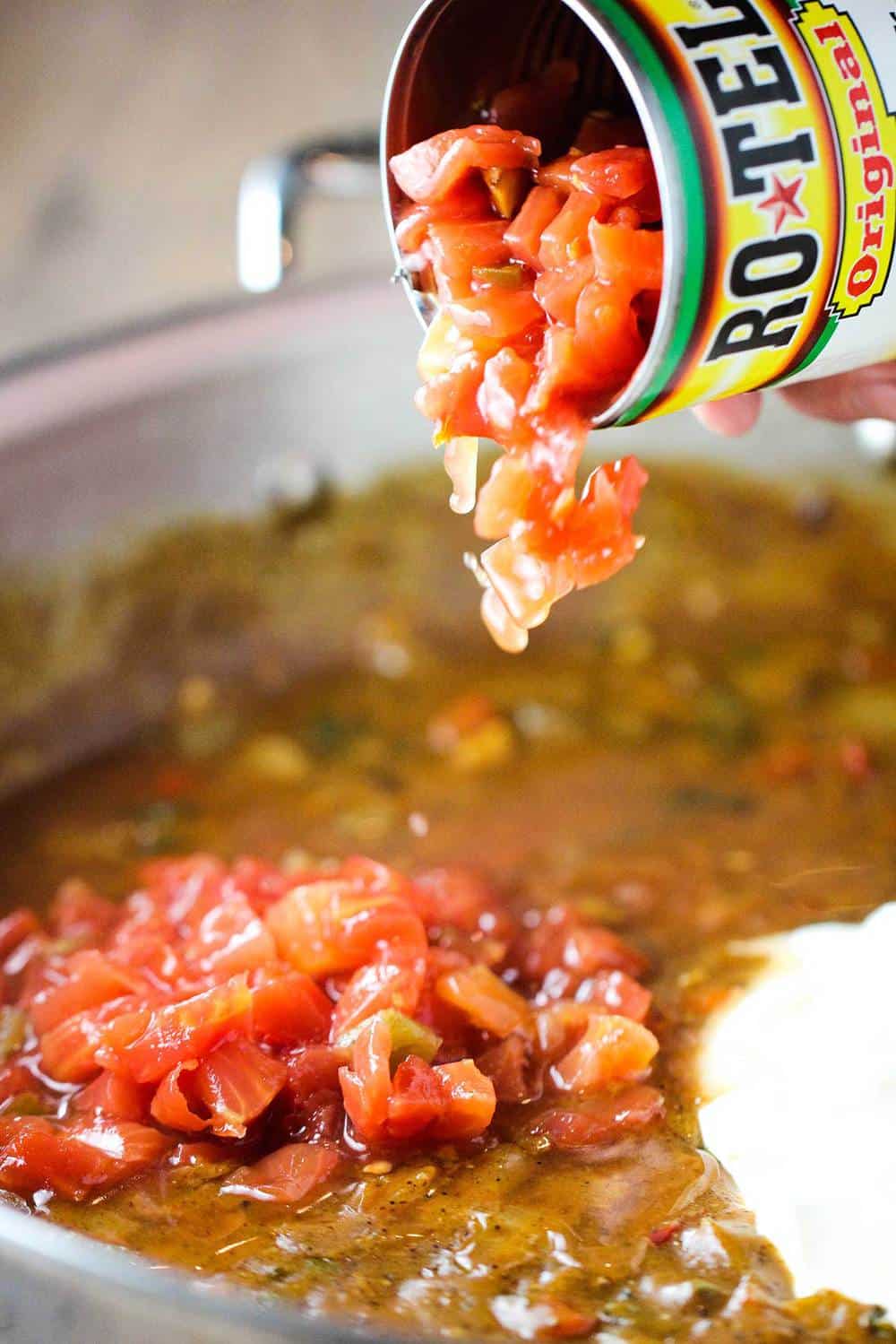 Can of Ro-tel tomatoes being dumped into skillet of king ranch casserole