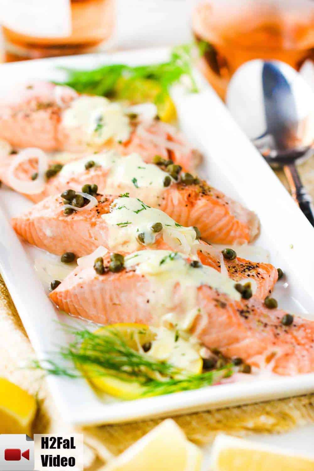 Poached salmon with capers and hollandaise sauce on a white platter