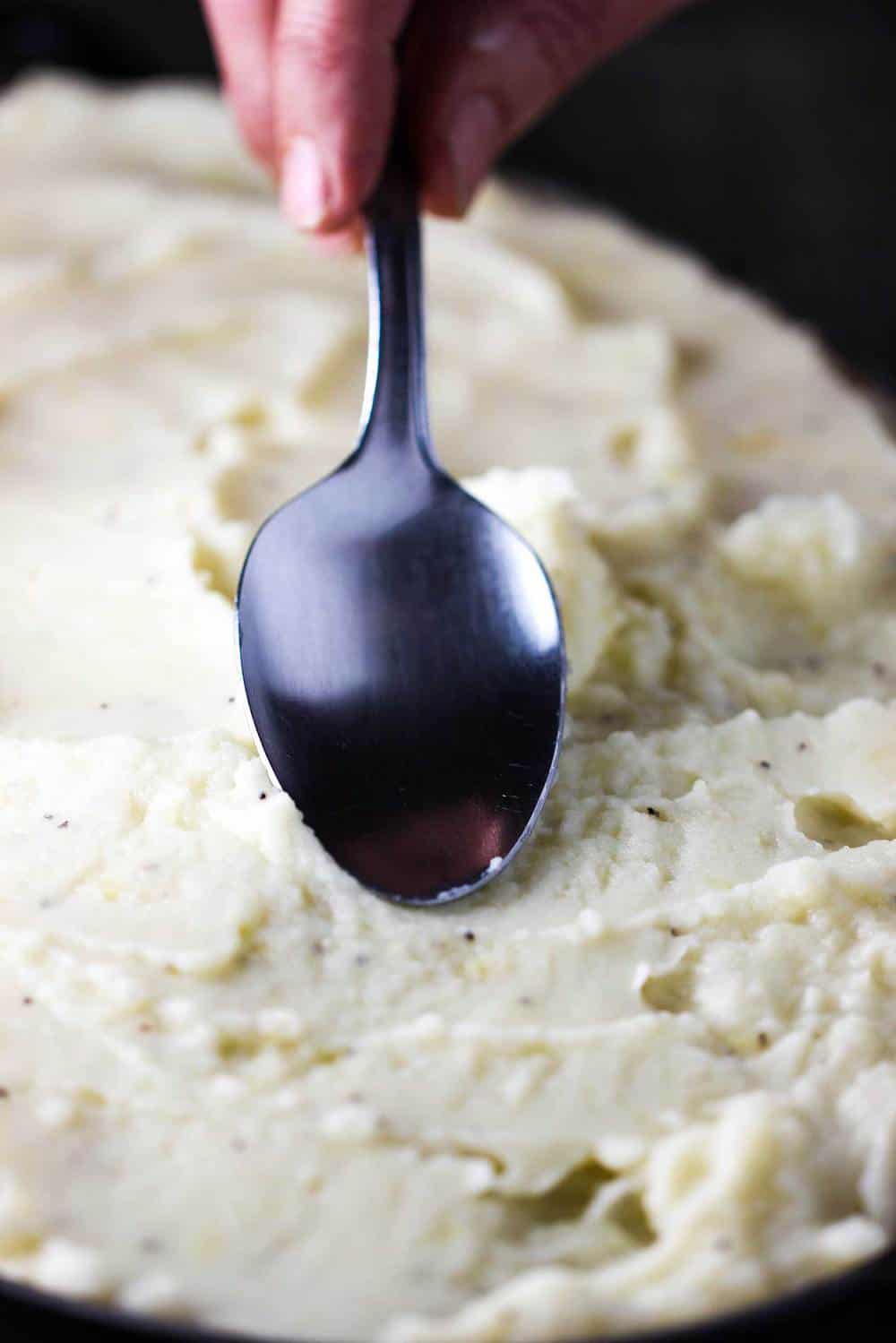 A spoon smoothing potatoes for Shepherd's Pie