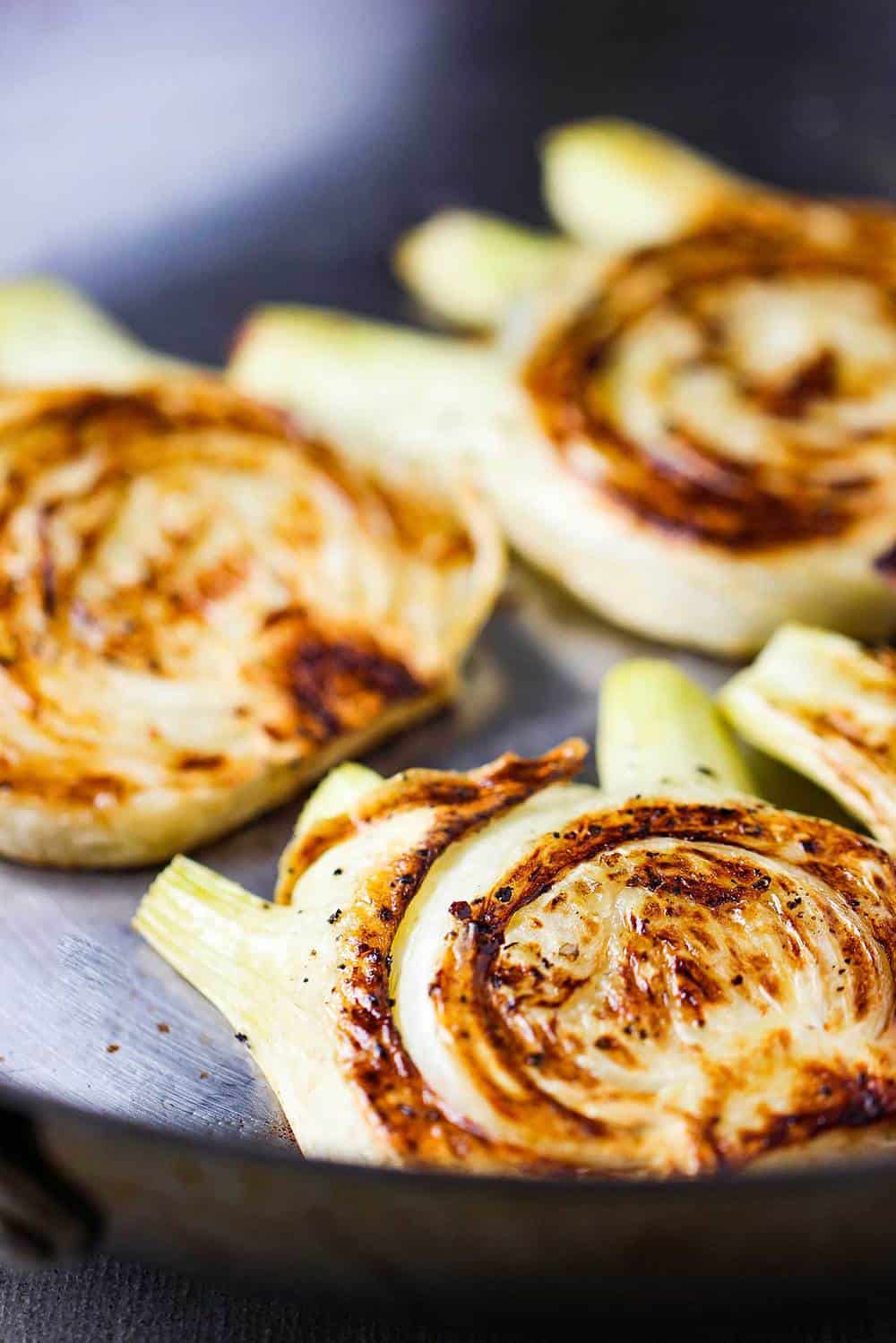 Slices of roasted fennel in a large skillet.