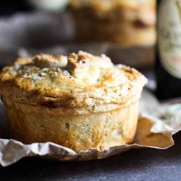 A Guinness beef pie sitting next to a bottle of Guinness beer.