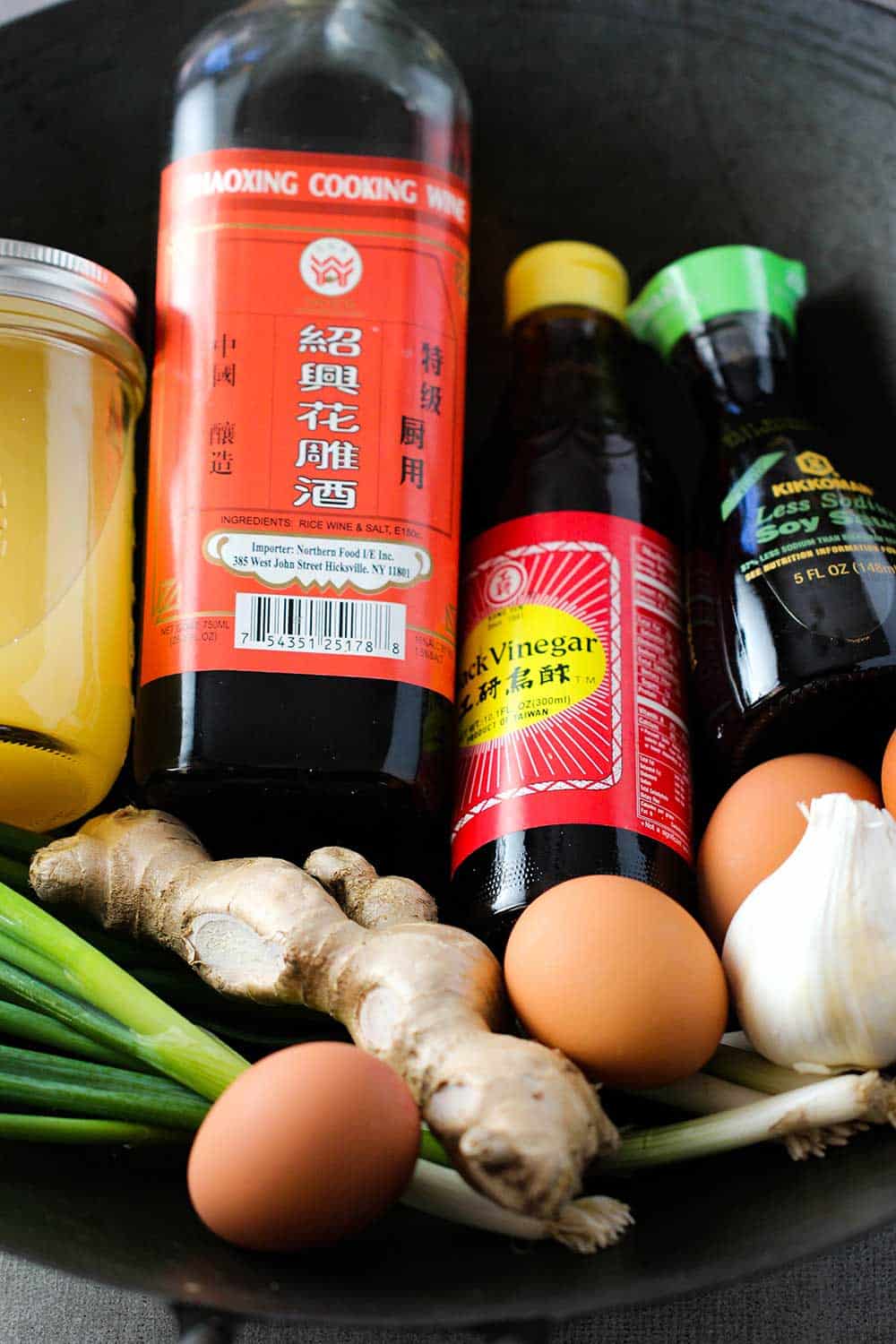 A steel wok filled with the ingredients to make sweet and sour pork.