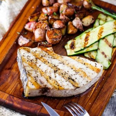 Grilled swordfish steaks on a cutting board