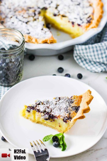 A slice of blueberry buttermilk pie on a white plate