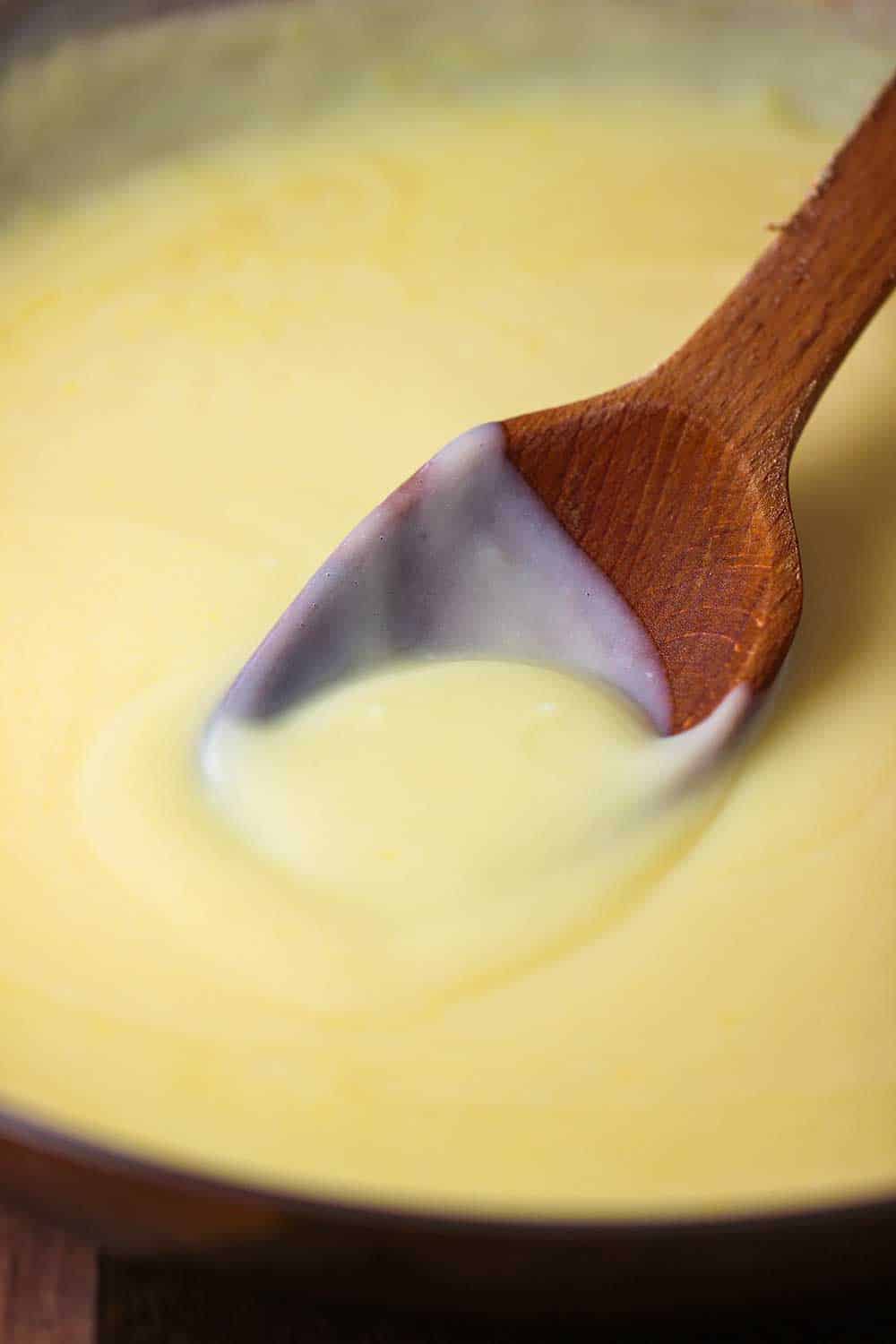 A wooden spoon finishes off homemade pudding for banana pudding