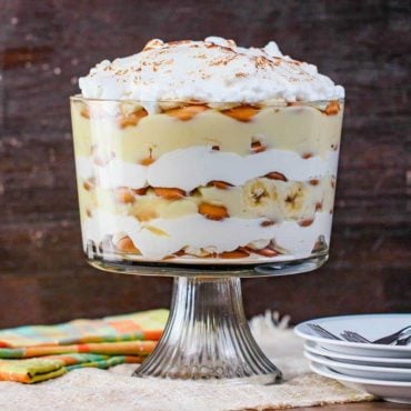 Banana Pudding next to a patterned napkin and a stack of white plates