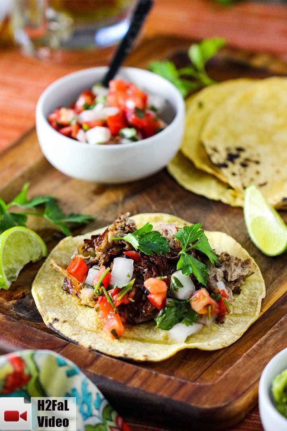 Place the shredded pork carnitas on a corn tortilla with pico de Gallo, cilantro and fresh lime. 