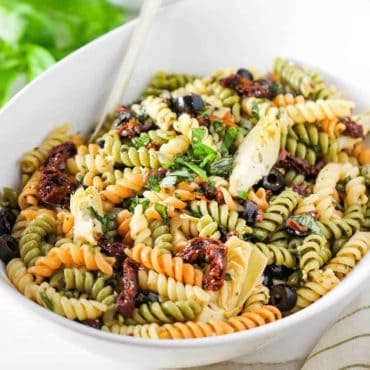 A white bowl containing fresh classic pasta salad.