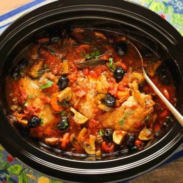 An overhead view of Provençal Chicken Stew in a large black slow cookers.