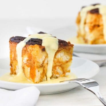 A plate of pressure cooker pumpkin bread pudding with vanilla custard sauce drizzled on top.