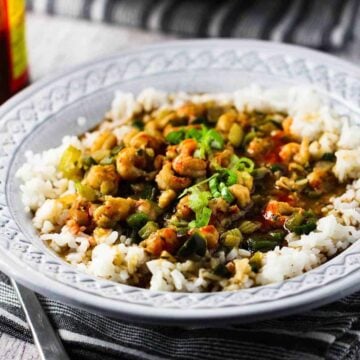 A grey bowl filled with crawfish étouffée and white rice.