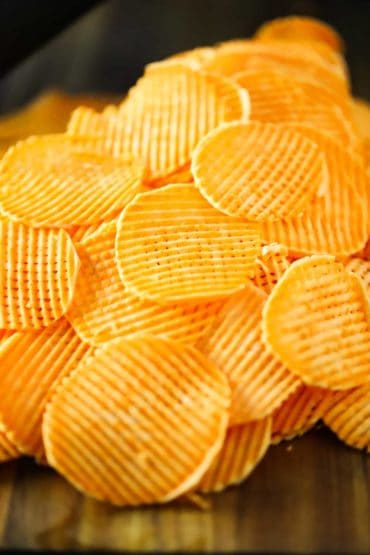 A stack of thinly slice sweet potato chips in a cross hatch style.