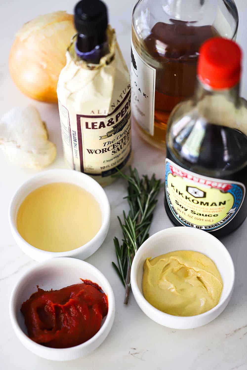 The ingredients for steak sauce including bowls of tomato paste, mustard, vinegar and bottles of soy sauce and Worcestershire