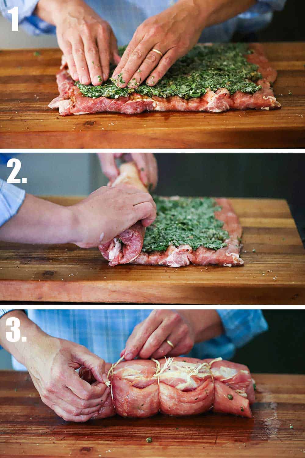 A flat rectangular piece of pork that a pair of hands is pressing herbs onto and then those hands rolling the loin and then the loin being tied together with twine.