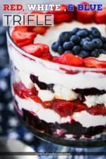 A red, white, and blue trifle sitting on a blue cloth dotted with white stars.