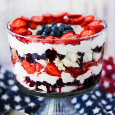 A red, white, and blue trifle sitting on a blue cloth dotted with white stars.