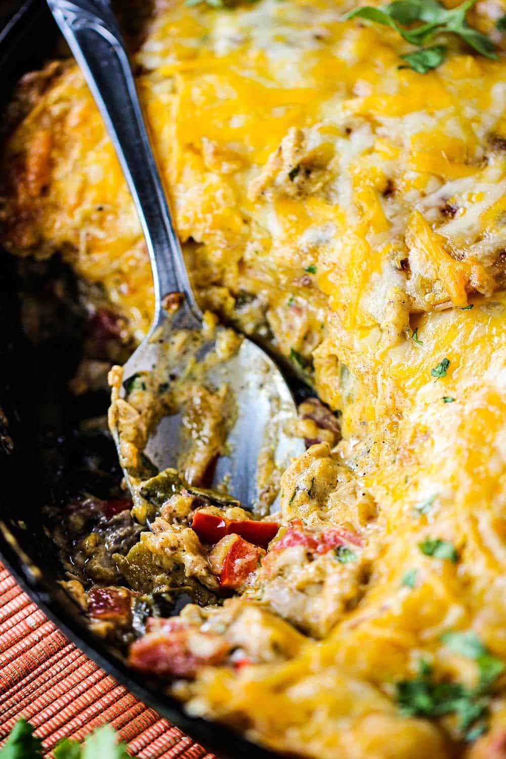 King Ranch casserole in a large cast iron skillet with a spoon in it