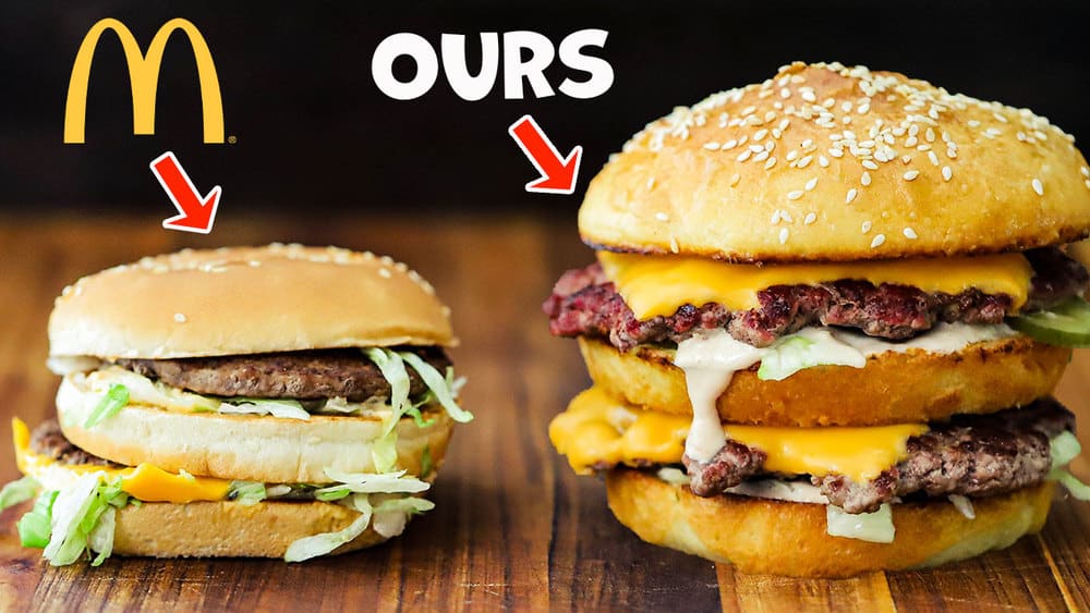 A McDonald's Big Mac sitting next to a homemade Big Mac both on a wooden cutting board.