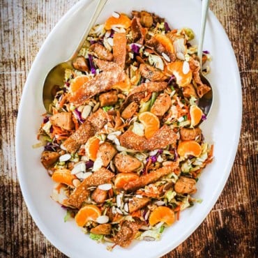 A large oval white platter holding a Chinese chicken salad.