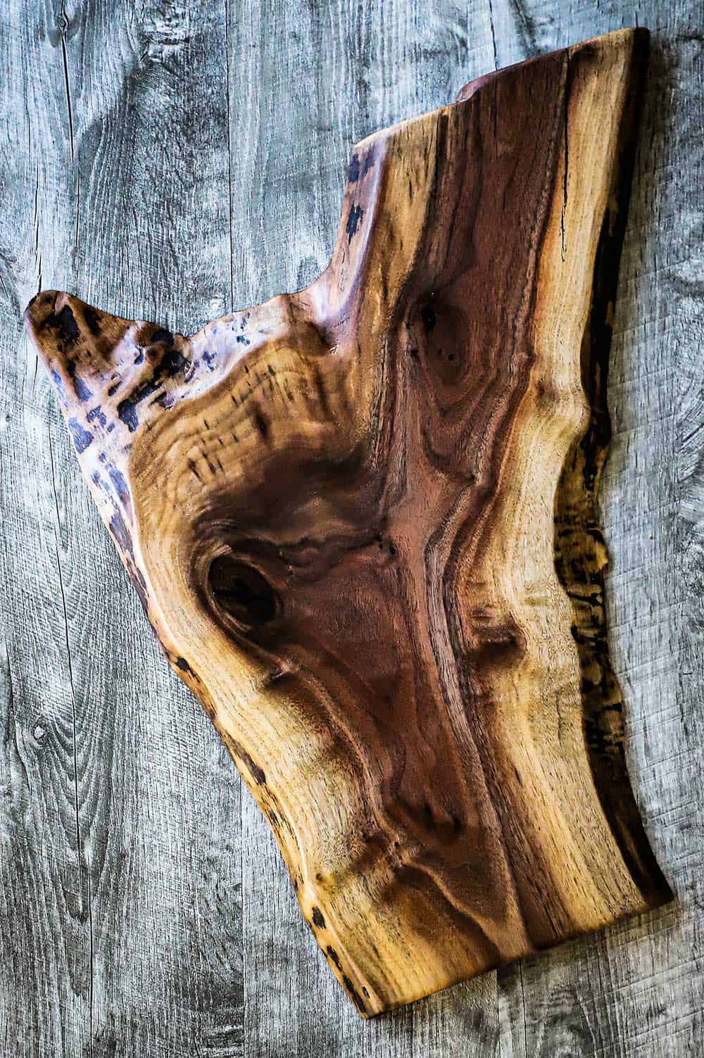 A large piece of wood that has been finished for using as a charcuterie board. 