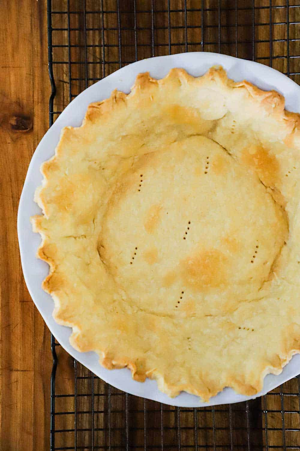 A pie crust that has been blind baked and then partially baked in a pie dish until lightly golden. 