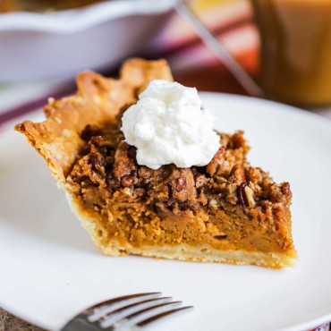 A slice of sweet potato pie sitting on a white dessert plate next to the pie in a pie dish.