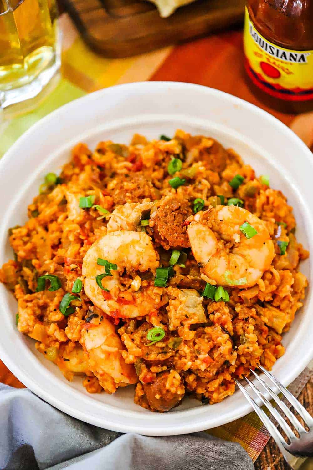 A white bowl filled with Louisiana jambalaya with a fork sitting on the side of the dish.