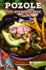 A color Mexican-style bowl filled with pozole and topped with avocado slices, radish slivers, and strips of fried corn tortillas.