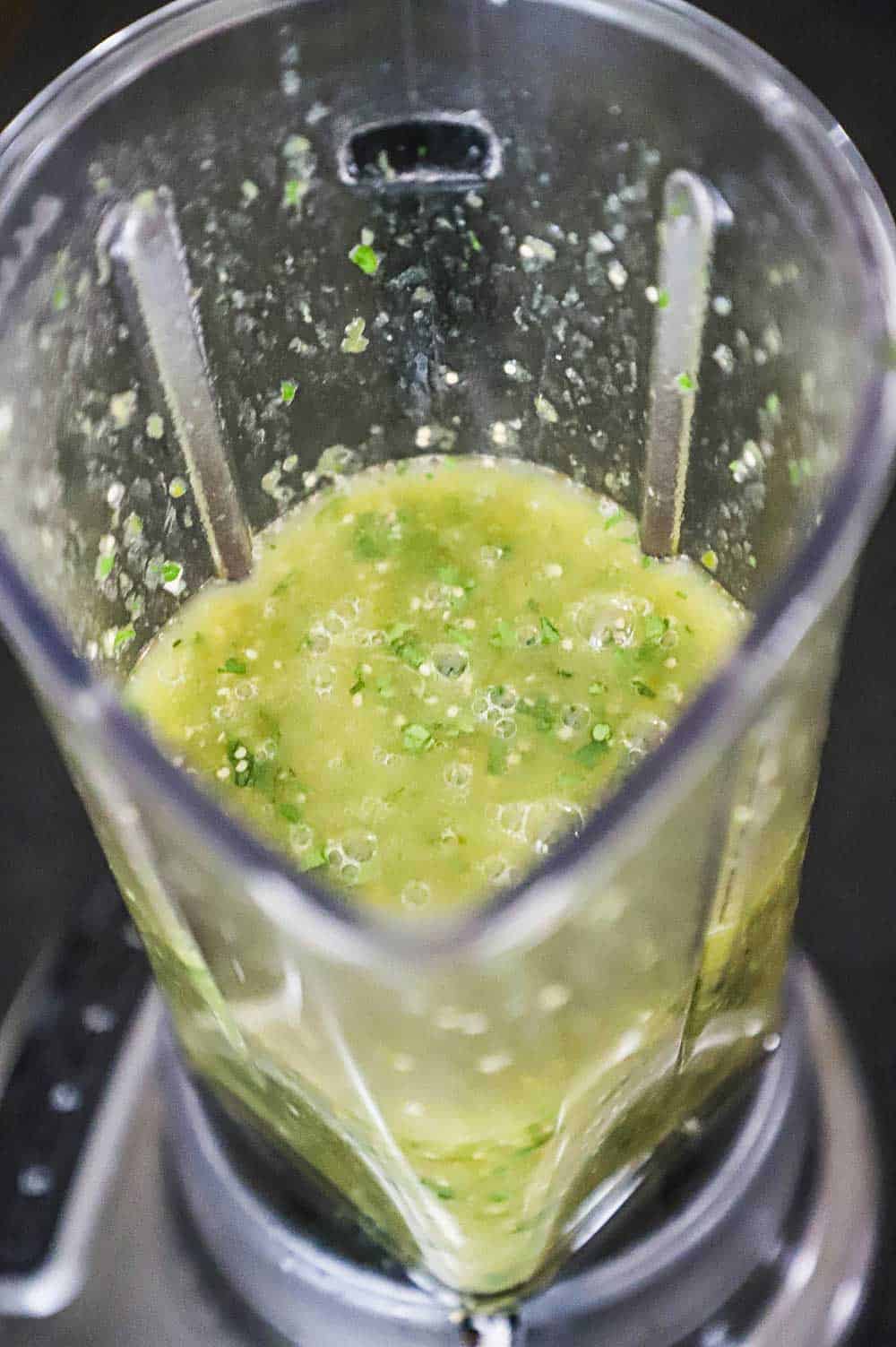 An overhead view of a blender filled with puréed salsa verde