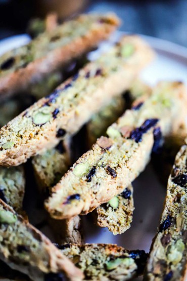 A close-up view of a stack of biscotti with pistachios and dried cherries.
