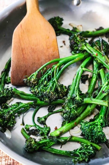 A large stainless steel skillet filled with sautéd broccolini